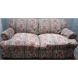 A modern two seat double hump back sofa on turned supports, with Nicky Haslam rose upholstery,