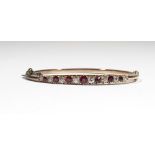 A ruby and diamond-set hinged bangle, claw-set with alternating cushion shaped rubies and diamonds,