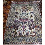 A fine Esfahan rug, Persian, the ivory field with a winged medallion, two flowering trees,