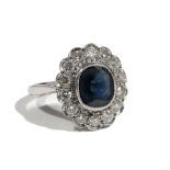 An 18ct gold, sapphire and diamond cluster ring, the central cushion-cut sapphire,