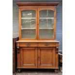 An early Victorian oak bookcase cabinet, the upper part enclosed by a pair of arched glazed doors,