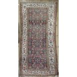 A Hamadan rug, with a large central panel of flowers and other motifs, on an abrashed field,