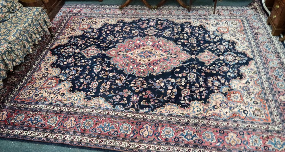 A modern Iranian carpet, with a central lozenge, surrounded by flowering branches,