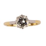 An 18ct gold ring, claw set with a circular cut diamond between platinum shoulders,