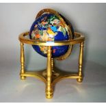 A modern table top terrestrial globe formed from specimen stone with gilt brass base,