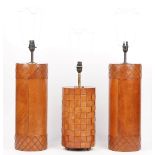 A pair of modern leather bound table lamps with silk shades and a smaller leather bound table lamp