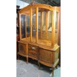 A modern stained beech display cabinet, with mirror back over two drawer base on cabriole supports,