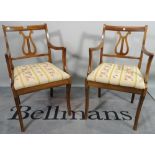 A pair of 19th century mahogany open armchairs, with lyre backs on sabre supports,