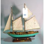 A modern wooden model of a sailing boat, 51cm wide x 51cm high.