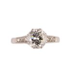 A platinum and diamond ring, claw set with the principal circular cut diamond to the centre,