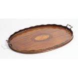 A 19th century marquetry inlaid oval serving tray, with wavy gallery, 67cm wide.