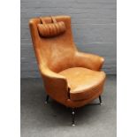 A retro design 1950s style tan leather armchair, on tubular metal supports, 90cm wide x 106cm high.