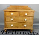 An early 20th century pine chest, of two short and two long graduated drawers,