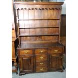 A modern oak dresser, with three tier plate rack over six short drawer cupboard base,