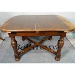 An 18th century oak extending dining table, on turned supports united by X-frame stretcher,