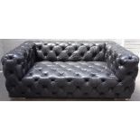 A black button leather upholstered two seat sofa, on chrome supports, 165cm wide x 65cm high.
