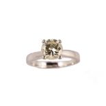 A platinum and diamond single stone ring, claw set with a circular cut diamond in a raised design,