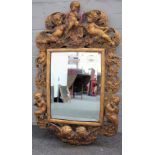 An 18th century style gilt plaster mirror, with cherub moulds and bevelled plate,