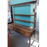 An 18th century oak dresser, the open two tier plate rack over three drawers, on block supports,