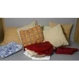 A group of assorted cushions and a bag of fabric and napkins.