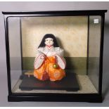 Two modern Japanese dolls in display cabinets, the largest 50cm wide x 45cm high.