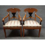 A pair of Biedermeier satin birch part ebonised open armchairs, on sabre supports,