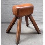 A tan leather upholstered pommel horse, on four splayed supports, 100cm wide x 100cm high.