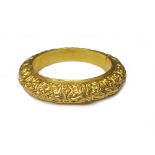 An Asian gold bangle, of circular hinged hollow form, with scrolling decoration,