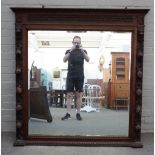 A 19th century oak mirror, with carved fruiting frame and bevelled plate, 137cm wide x 136cm high.