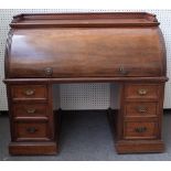 A Victorian mahogany roll top desk, with fitted interior, over six pedestal drawers,