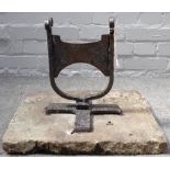 A Victorian cast iron boot scraper with scroll finials, set into a rectangular stone slab,