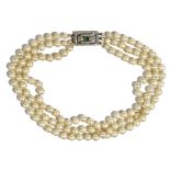 A three row necklace of imitation pearls, on a diamond and emerald rectangular clasp,