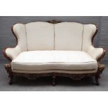 An 18th century Italian style parcel gilt mahogany sofa, with shaped back and scroll supports,