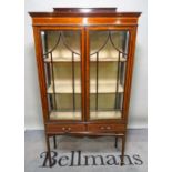 An Edwardian mahogany display cabinet, with two short drawers on tapering square supports,