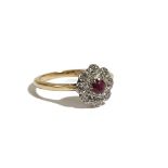 An 18ct gold ring, claw set with a circular cut ruby in a surround of eight circular cut diamonds,