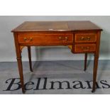 An Edwardian inlaid mahogany writing desk, with single drawer on tapering square supports,