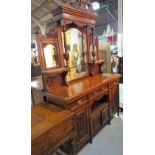 A late Edwardian mahogany sideboard, the mirrored back over carved panel doors on turned supports,