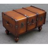 A coffee table formed as a wood and leather bound travelling trunk, on turned feet,