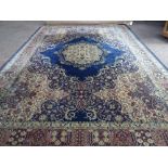 A Wilton carpet, machine made of Persian design, the dark blue field with bold centre medallion,