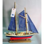 A modern wooden model of a sailing boat, 55cm wide x 61cm high.