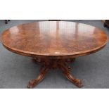 A Victorian figured walnut oval snap top loo table, on four carved downswept supports,