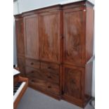 A George III mahogany breakfront compactum wardrobe with central cupboards over two short and two