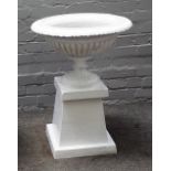 A white painted cast iron urn, on a tapering square stand, 74cm diameter x 78cm high.