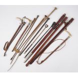 A collection of fourteen riding crops and sword sheaths, together with gun cleaning rods.