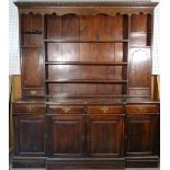 A mid-20th century oak dresser, with three tier plate rack flanked by cupboards,