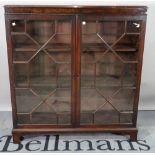 A Regency style mahogany display cabinet, with astragal glazed doors on bracket feet,