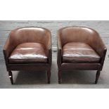 A pair of Regency style leather upholstered tub back armchairs, on turned supports,