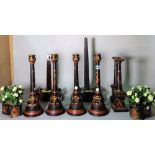 Two hardwood weighted plate stands, 45cm tall, a quantity of modern painted candlesticks, 38cm tall,