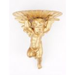 A late 19th century giltwood wall bracket, carved as an angel supporting a clam shell, 32cm high.