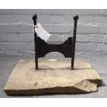 A Victorian cast iron boot scraper with canted square finials, set into a rectangular stone slab,